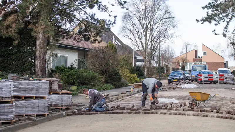 Crew working on a neighborhood sidewalk section near a house